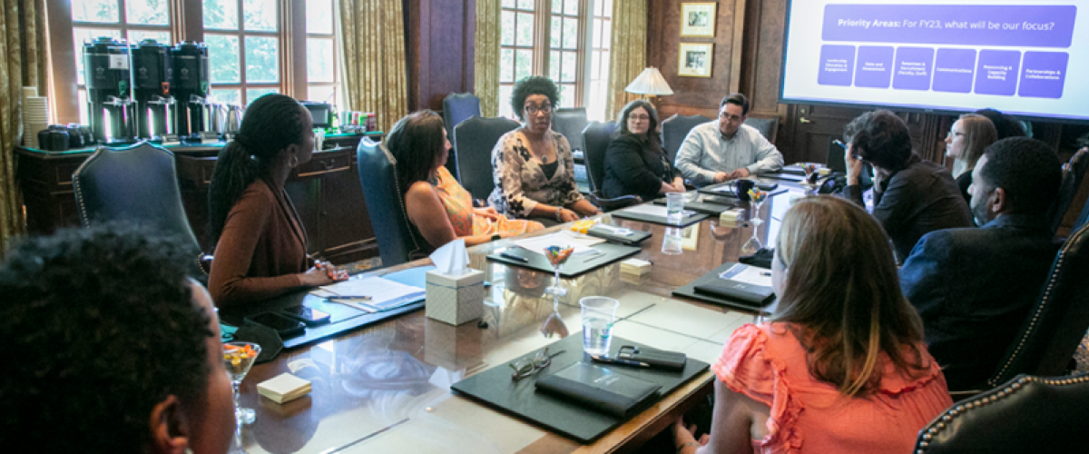 People from the office of equity, diversity and inclusion a boardroom table.