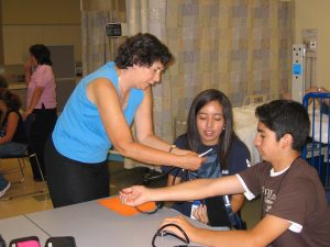 Instructor swabbing the elbow of two teens