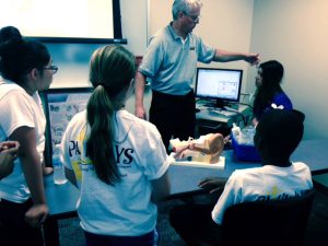 instructor demonstrating procedure on young student while others students watch