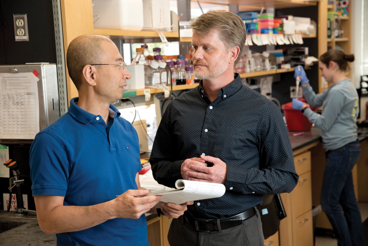 two men speaking in a lab