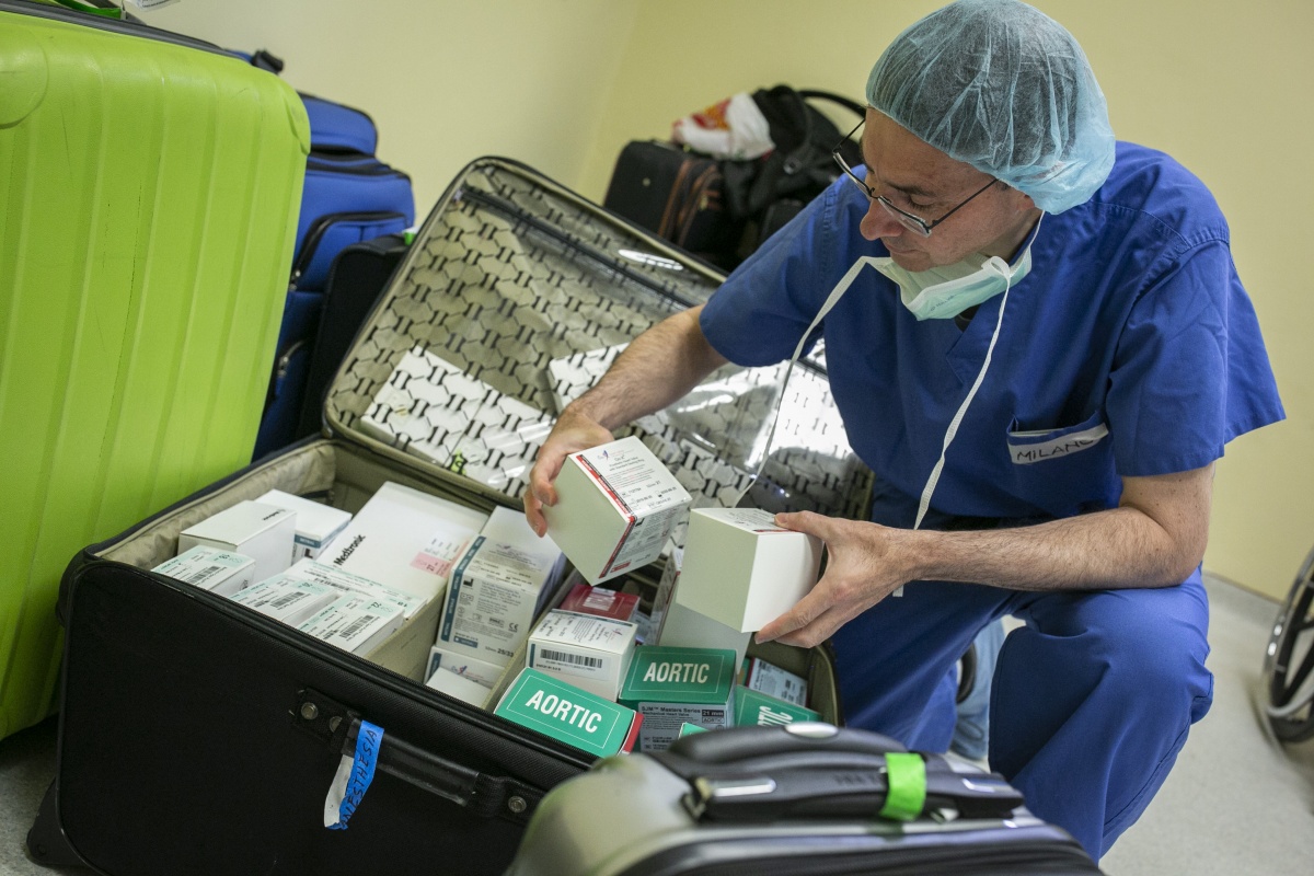 physician looks at medical supplies in a bin