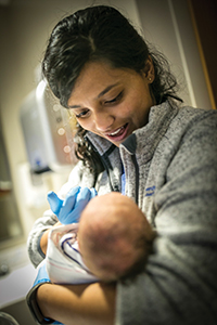 Shree Bose holding a newborn baby
