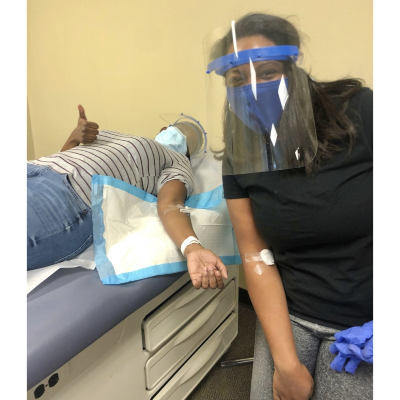 Moore-Byers wearing mask and face shield next to student on exam table