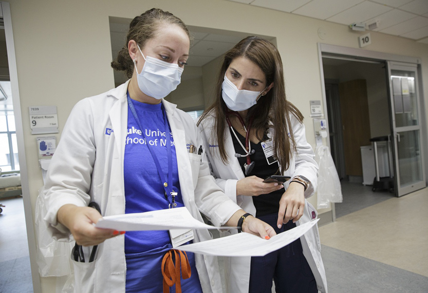 Duke Cardiology fellows examine paperwork in the Cardiac Intensive Care Unit at the Duke Medical Pavilion.