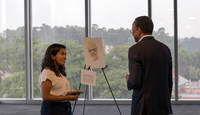 Sonali Biswas shows Duke Chancellor For Health Affairs A. Eugene Washington, MD, a portrait she created of her community partner