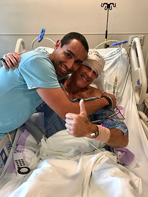 man hugging another man in a hospital bed