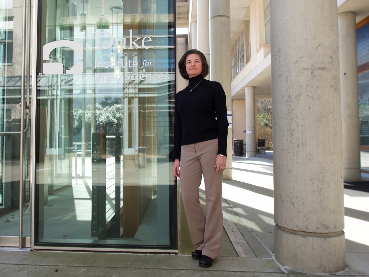 woman standing outside door to Duke Institute for Brain Sciences