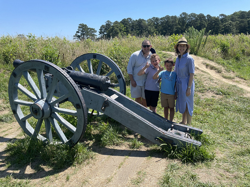 Salama's spouse and two children standing by a cannon on the Yorktown Battlefield