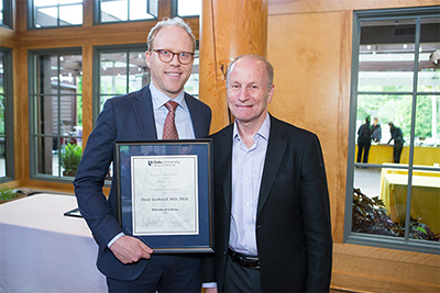 Derek Southwell, MD, PhD, (left) receives the Whitehead Scholar award presented by Steve Lisberger, PhD (right) at the 2019 Duke School of Medicine Spring Faculty Meeting.