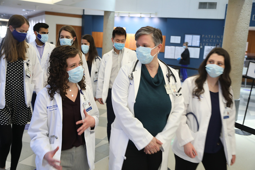 Nancy Weigle, MD, leads medical students into the clinics at Duke medical center to observe patients.