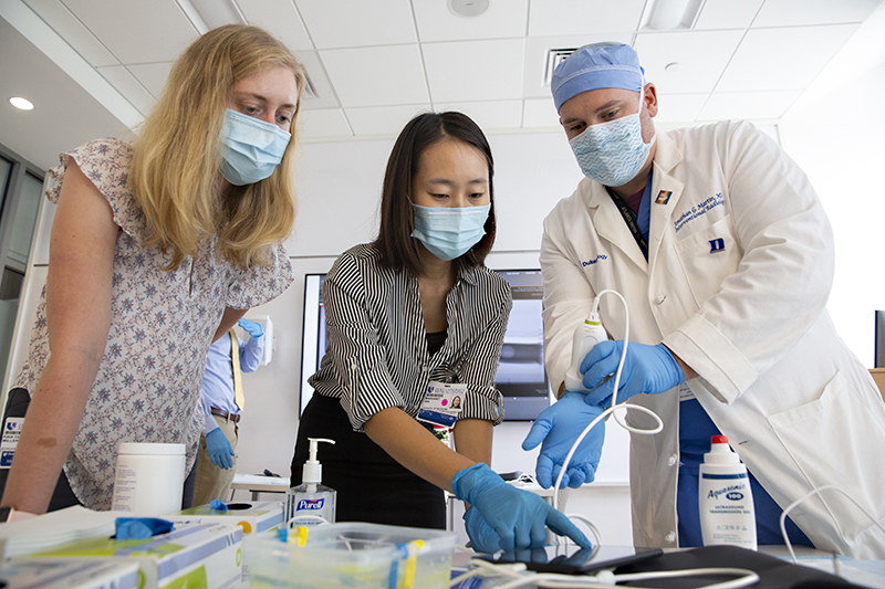 Medical students Kaia Miller and Maggie Min learn how to operate an ultrasound machine with radiologist Jonathan Martin, MD.