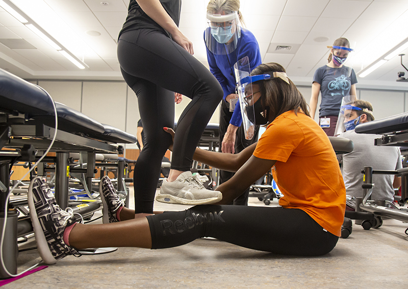Glenda Holcomb, a second-year Doctor of Physical Therapy student, practices leg stretching with a fellow student 