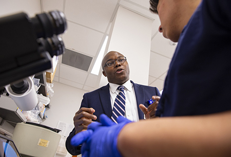 Dr. Olabisi talks with a lab member.