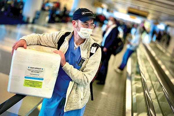 physician holding cooler walking through airport