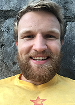 Headshot of student Franz Belz in front of stone wall