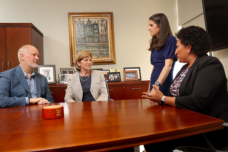 group of four people at conference room table