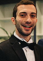 Headshot of student Husam Mikati smiling at camera wearing jacket and bow tie
