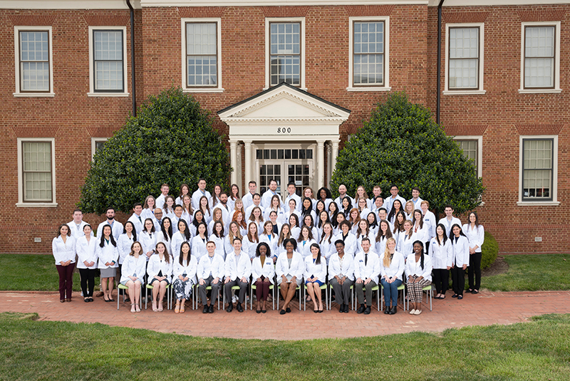 large group photo of class of students in white coats