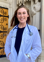 Student Hunter Aitchison in white coat and stethoscope smiling at camera
