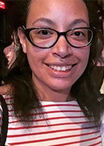 Student Alyssa Bartlett smiling at camera wearing black rimmed glasses and red and white shirt
