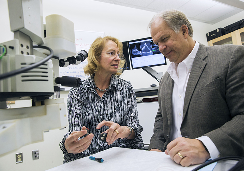 woman and man looking at technology in lab