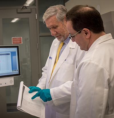 Tomas Denny and coworker in the lab looking at test results