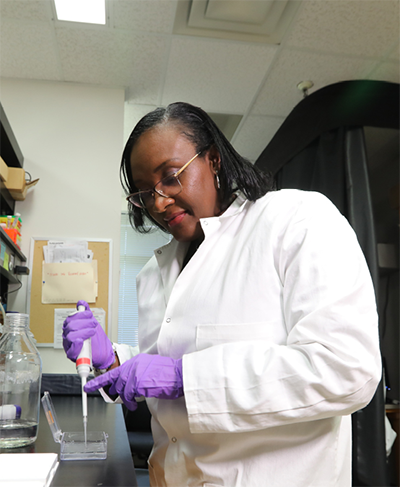 Carlene Moore, PhD in her lab pipetting 