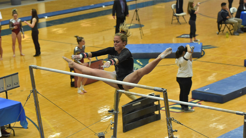 Tori Kinamon on the uneven bars gymnastic event