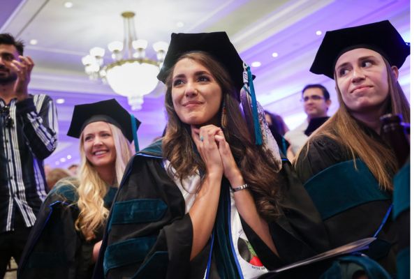 Three women in cap and gown at their graduation