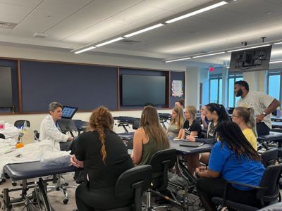 A faculty member in a class, surrounded by students