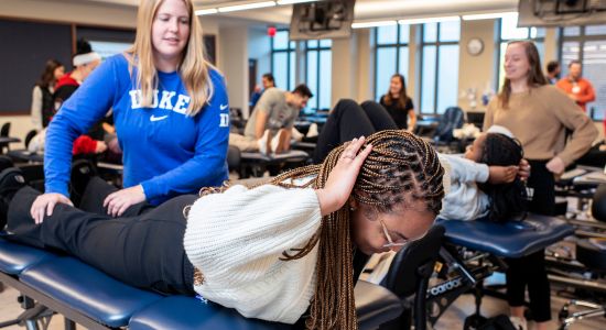 Two students practicing a manual therapy movement 