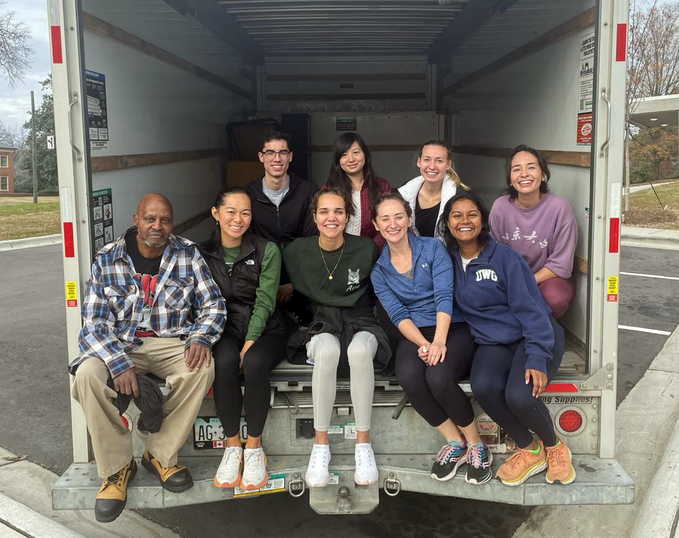 Students and one of the neighbors in the back of a moving truck.