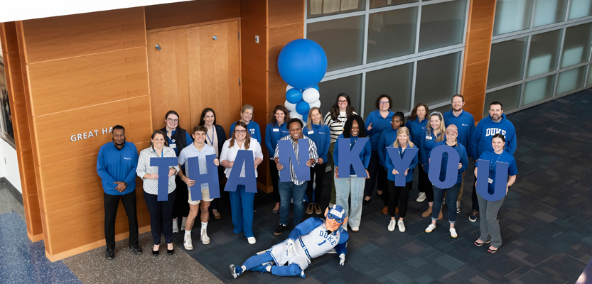 Group photo of DHDAA staff and Duke Blue Devil holding letters spelling out Thank You