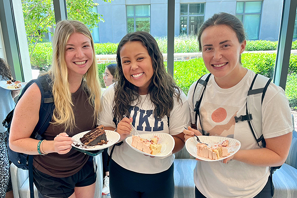 3 Duke DPT students smiling and eating cake