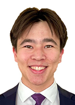 Headshot of Reid Chen smiling at camera in front of white backdrop wearing purple tie
