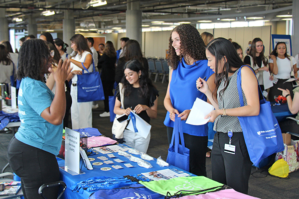 students talking to a representative at a fair booth