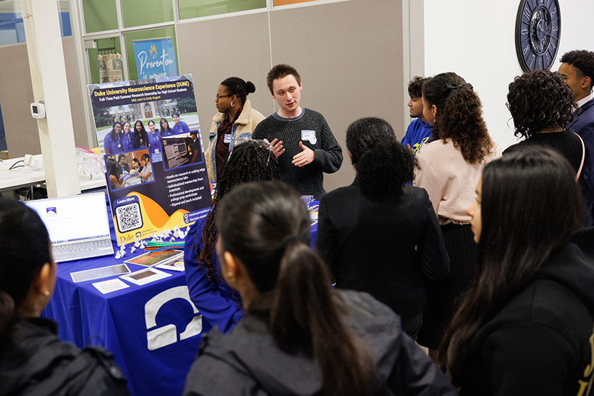 Owen Traubert, a graduate student in Duke’s Biomedical Engineering Department, talks to young students.  