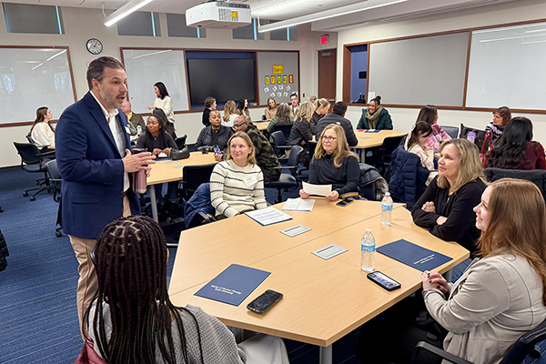 Dr. cade speaking with a table of open house guests