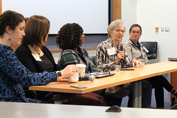 five professors at a table, one of whom is talking