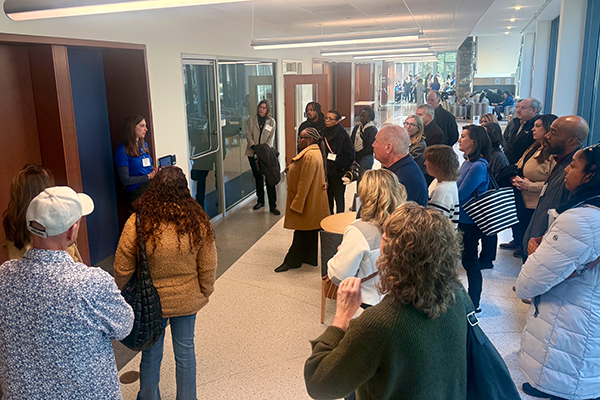 a student talking to a few dozen open house guests