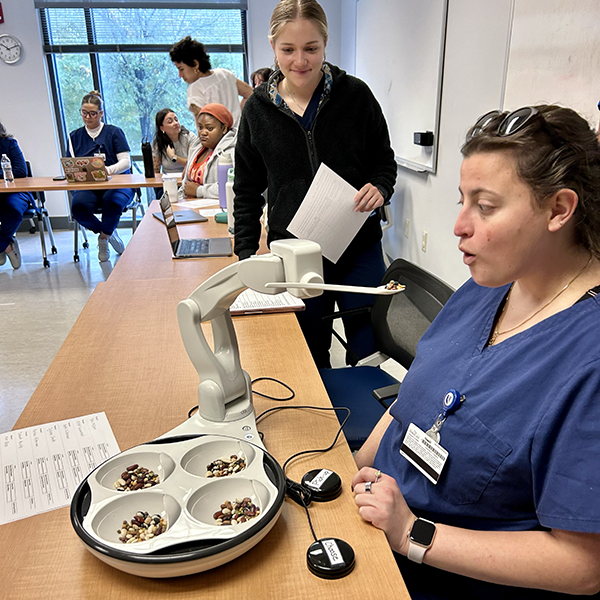 a student using an assistive technology device to eat