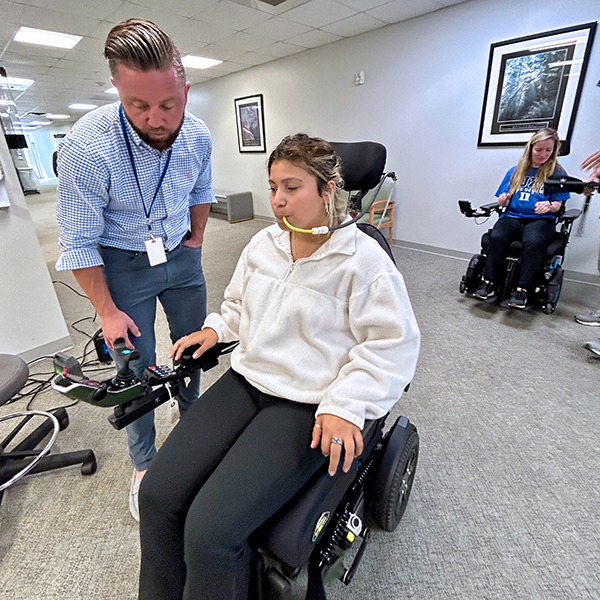 Fatima in a wheelchair receiving instruction