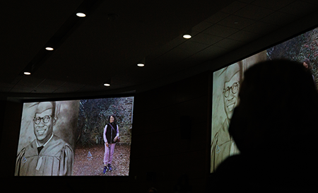 audience member watching the unhealed presentation in a darkened lecture hall