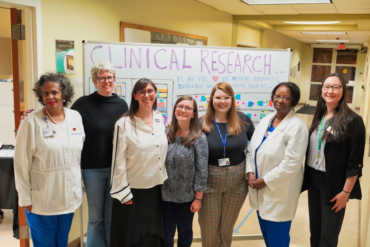 Image of team at Durham Early College of Health Sciences event with Clinical Research board as a backdrop