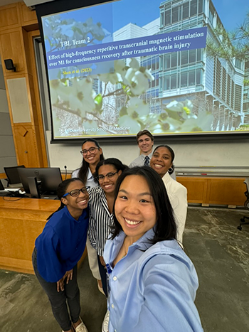 Alexis Pean and her classmates posing for a selfie in front of a podium