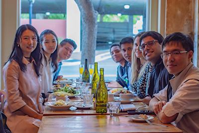 Veronica Russell at dinner in a restaurant with her classmates