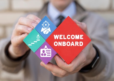 hands holding "welcome onboard" sign