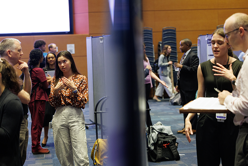 Sydney Sheffield, left, and Francyess Denis Oliva, right, speak about their research during the student poster presentation