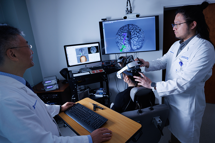 Wayne Feng, MD, left, and Ziping Huang, PhD student in biomedical engineering, right, demonstrate a LIFUS session