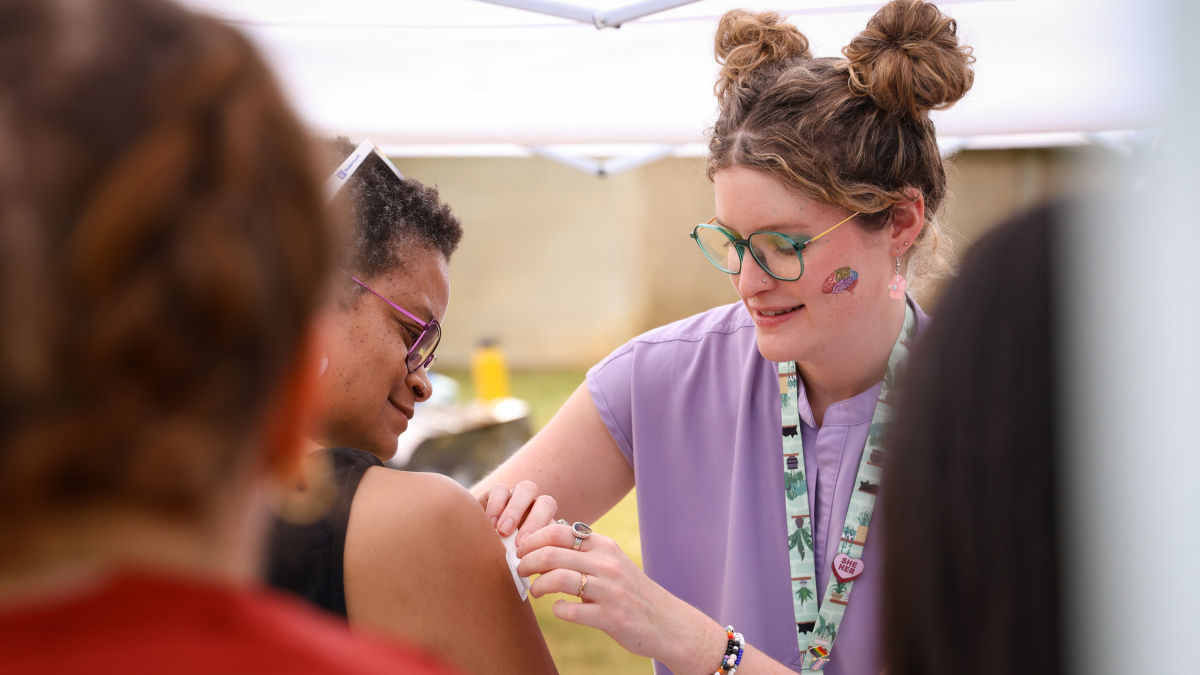 Tonia Poteat, PhD, (left) professor in the School of Nursing, visits with second-year PA student, Lindsey Zipperer, at the Duke Physician Assistant Program booth. 